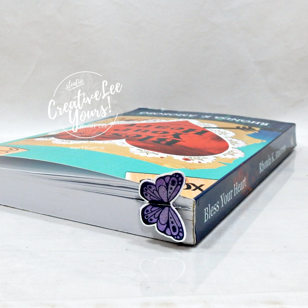 DIY butterfly bookmark handmade from patterned paper clipped into a book